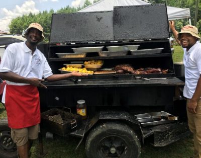 Chef Cheez’s original website photograph of family working beside a grill